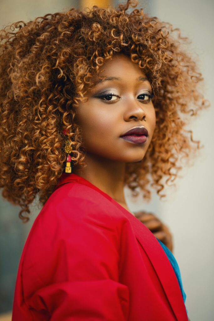 pexels-photo-718978-718978 Striking portrait of a woman with curly hair, wearing a red jacket.